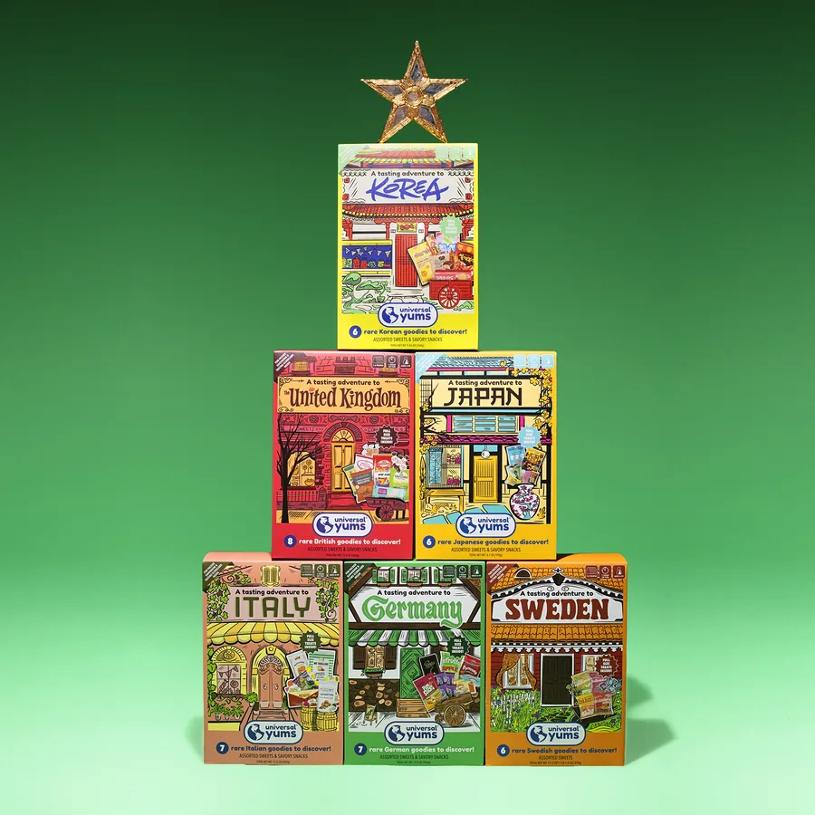 The six tasting set boxes stacked as a tree with a gold star on top, on a green background.