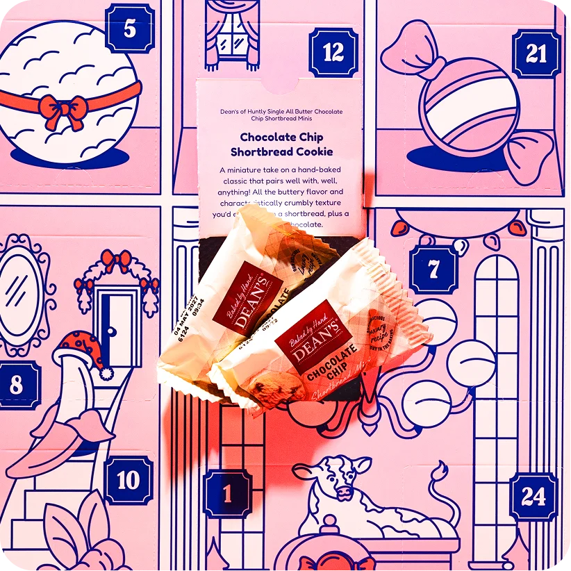 Two candies in front of the illustrated numbered doors of a Grand Yums Hotel advent calendar.